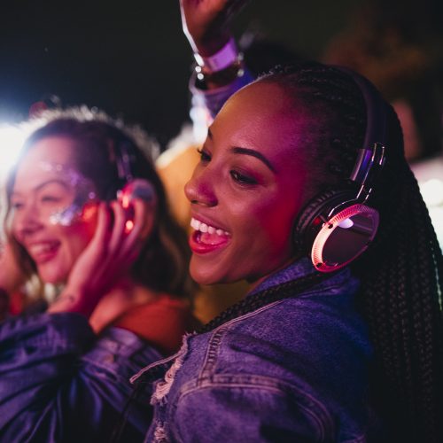 Young women are having fun and dancing in a silent disco at a music festival.